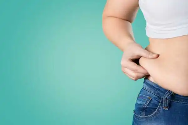 Image of woman pinching her love handles to show weight gain Skegness
